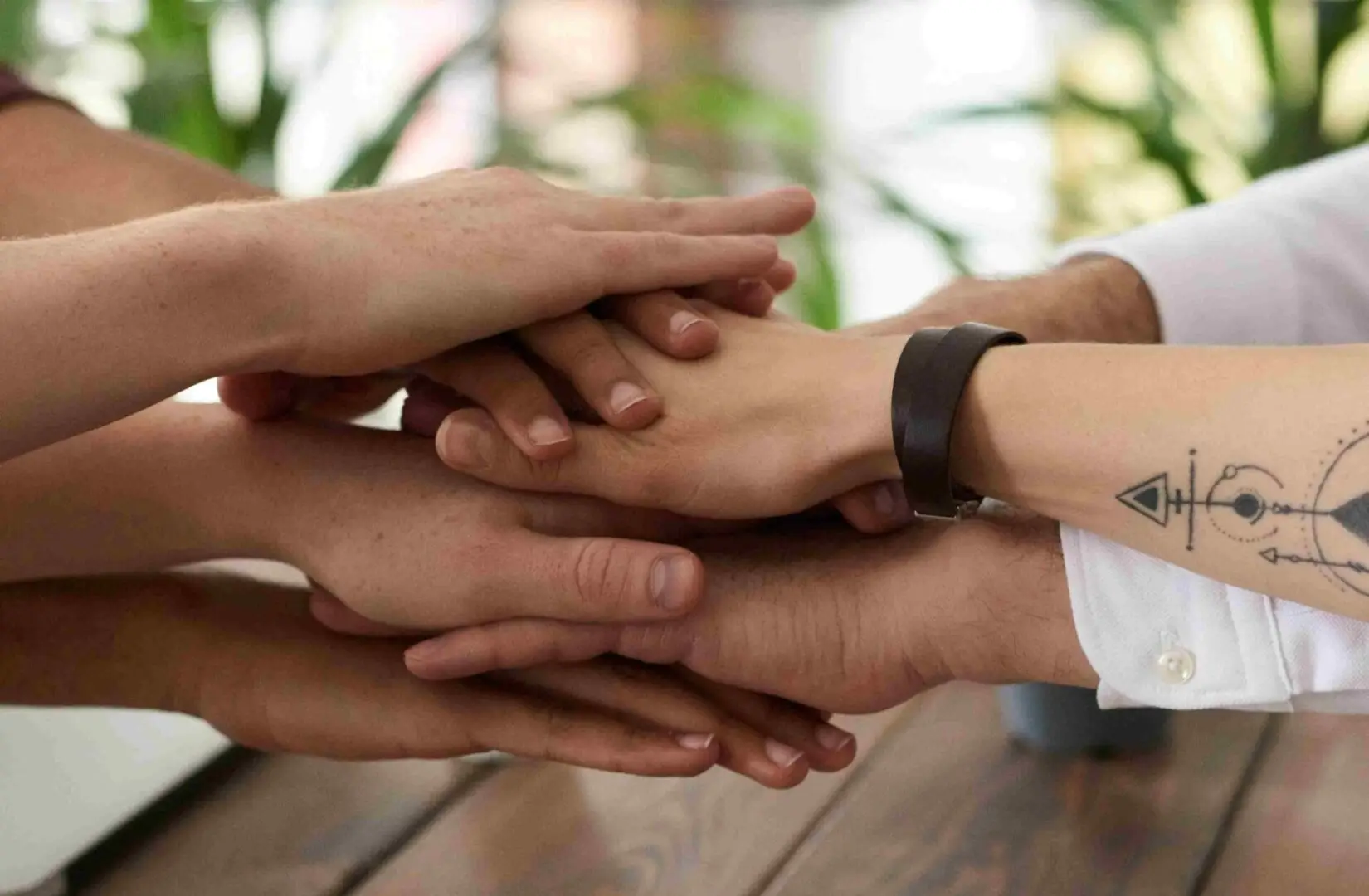 Diverse group of hands stacked together in a gesture of unity and support