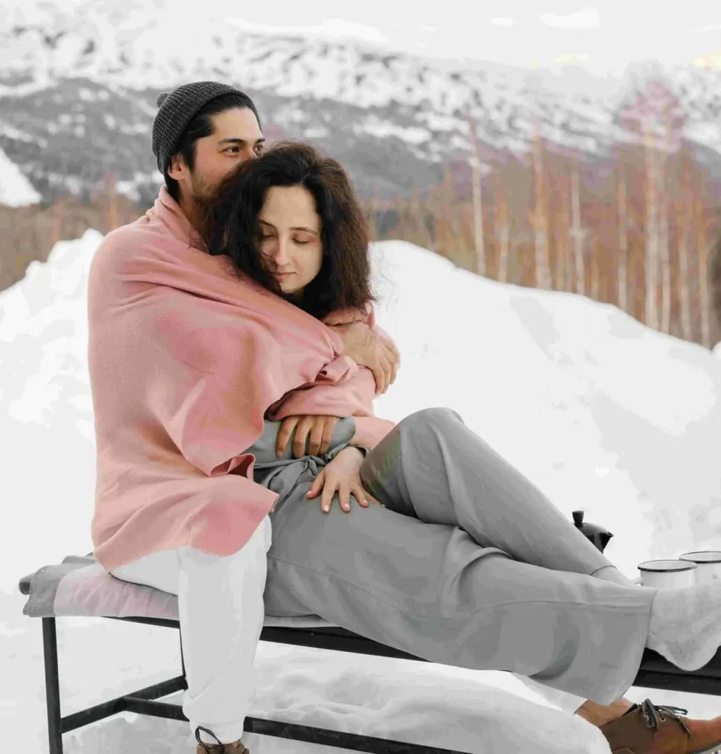 Couple hugging in a snowy scene.